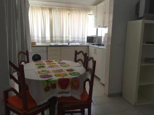 a kitchen with a table and chairs with a table cloth at Casinhas de Alfenim in Sesimbra
