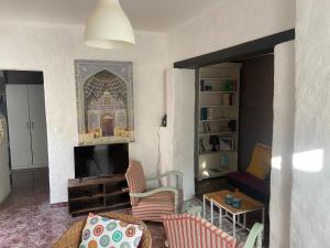 een woonkamer met een flatscreen-tv en een bank bij Casa Las Cuevas in Málaga