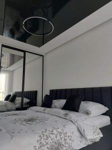 a bedroom with a large bed with a mirror at Westin House Black in Kołobrzeg