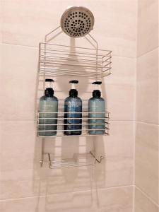 a rack with three bottles of water in a bathroom at Kelley House in Pensacola