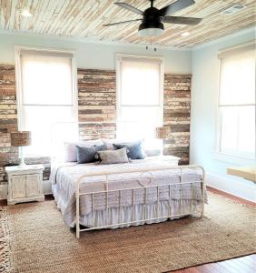 1 dormitorio con 1 cama con pared de madera en Kelley House en Pensacola