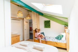 a woman sitting on a bunk bed in a bedroom at SURF HOSTEL BIARRITZ in Biarritz