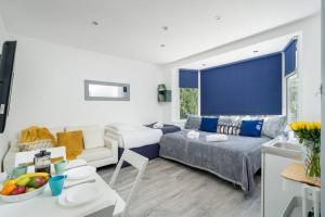 sala de estar con sofá y mesa en A Bright Lovely Spacious Studio. en Woodford Green