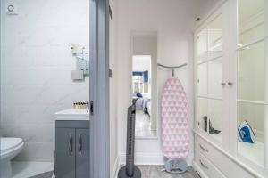a bathroom with a shower and a toilet and a sink at A Bright Lovely Spacious Studio. in Woodford Green