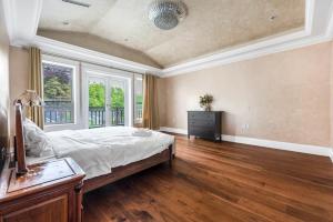 1 dormitorio grande con 1 cama y suelo de madera en No. 2温哥华市中心舒适优雅独立卫生间大床套间 en Vancouver