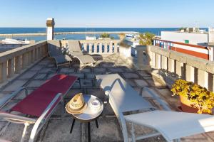 een balkon met stoelen en tafels en de oceaan bij Casa Cuore di Nonna in Savelletri di Fasano