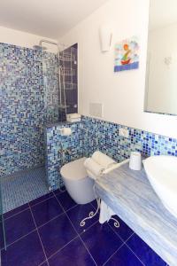 een blauw betegelde badkamer met een wastafel en een toilet bij Casa Cuore di Nonna in Savelletri di Fasano