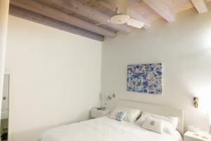 een slaapkamer met witte muren en een bed met kussens bij Casa Cuore di Nonna in Savelletri di Fasano