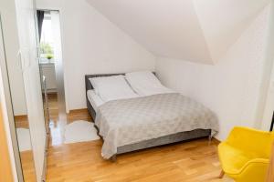 ein Schlafzimmer mit einem Bett und einem gelben Stuhl in der Unterkunft Apartament na Górnej in Puńsk