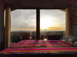 1 dormitorio con vistas a una cama con ventana en Alojamiento Lago Titicaca, en Puno