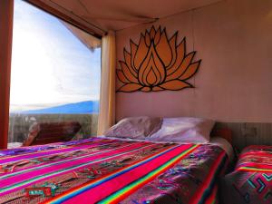 1 dormitorio con 1 cama con una pintura en la pared en Alojamiento Lago Titicaca, en Puno