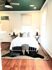 a bedroom with a bed and two windows and a ceiling at Kelley House in Pensacola