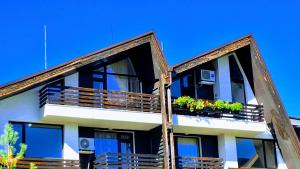 un edificio con 2 balcones con macetas. en Aspen Suites A403 - Sky & Stars Dreamers, en Razlog