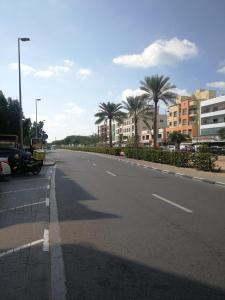 una strada vuota con palme ed edifici di UAE HOSTEL a Dubai