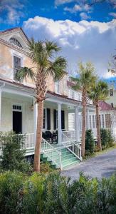 uma casa grande com palmeiras em frente em Sparrow at Casa Zoe em Charleston