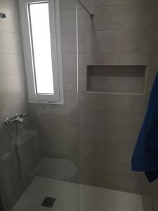een badkamer met een glazen douche en een raam bij Casa Merlín Arena in Playa Honda