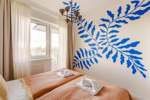 a bedroom with a blue flower mural on the wall at Blue Marine Apartment in Kołobrzeg