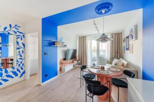 una sala de estar azul y blanco con mesa y sillas en Blue Marine Apartment en Kołobrzeg