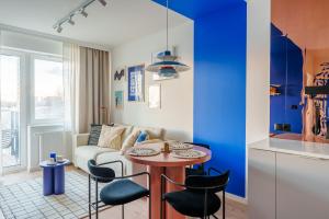 a living room with a couch and a table and chairs at Blue Marine Apartment in Kołobrzeg