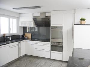 una cocina blanca con armarios y electrodomésticos blancos en Ferienwohnung Canols für 6 Personen Valbella-Lenzerheide, en Valbella