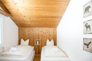 2 camas en una habitación con techo de madera en Ferienwohnung Canols für 6 Personen Valbella-Lenzerheide, en Valbella