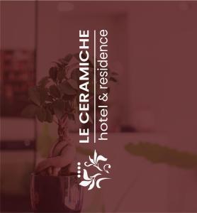 蒙塔爾圖富戈的住宿－Le Ceramiche - Hotel Residence ed Eventi，花瓶中的植物,带有读物的标志