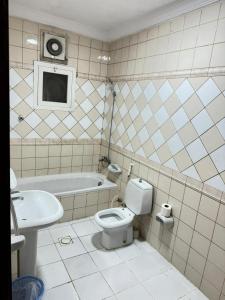 a bathroom with a toilet and a sink and a tub at الاصايل 1-طريق الاربعين in Al-Safa