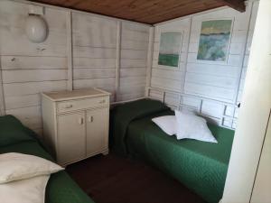 a small room with a green bed and a cabinet at Camping Smeraldo in Trevignano Romano +88 photos