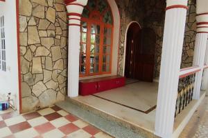 einen Eingang zu einem Haus mit einer roten Tür in der Unterkunft Luxurious & Spacious 4BHK Villa with AC at City Centre, Pearl Stayz in Mysore