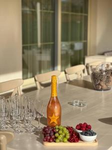een fles wijn en druiven op een tafel met glazen bij Villa Alma 1910 Starosel in Starosel