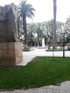 un parque con una fuente, palmeras y césped en Gutierrez Home en Mendoza