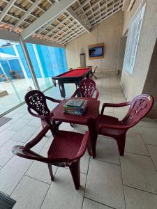 卡波布里奧的住宿－Casa para temporada super confortável 6km praia do forte Cabo Frio，房间里的两张乒乓球桌和椅子