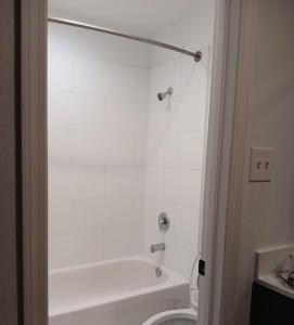 uma casa de banho com uma banheira branca e um WC. em StateLine Stayovers Extended Stay Hotel em Texarkana