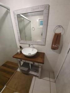 een badkamer met een wastafel en een spiegel bij Chalé Villa das Hortênsias in Annitapolis