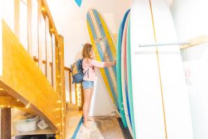 a woman is standing next to a bunch of surfboards at SURF HOSTEL BIARRITZ in Biarritz