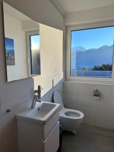 een badkamer met een toilet, een wastafel en een raam bij Apartment Bloserberg in Thüringen