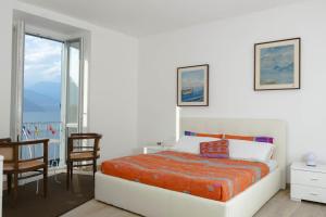 a bedroom with a bed and a table and chairs at Apartment Laghée in Bellano