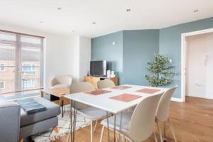 a dining room with a white table and chairs at Refurbished bright and cosy 2 bedroom apartment next to Stratford hot spots in London
