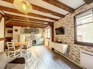 een keuken en een woonkamer met een tafel en stoelen bij Aux Deux Tours in Riquewihr