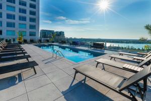 una piscina con sedie a sdraio e un edificio di Hyatt Centric Montreal a Montréal