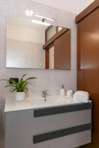 a bathroom with a sink and a mirror and a plant at La piazzetta in Vedano Olona