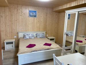 a bedroom with a bed and two bunk beds at Садиба У Дохтора Відпочинок у Карпатах in Golubinoye