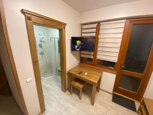 a bathroom with a wooden desk and a shower at Садиба У Дохтора Відпочинок у Карпатах in Golubinoye