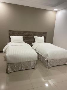 two beds sitting next to each other in a bedroom at دار المسك in Dammam