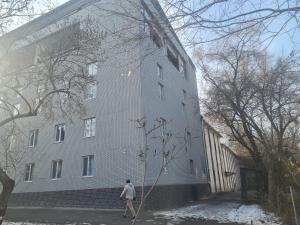 a man is standing in front of a building at Квартира 1 комн in Almaty