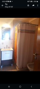 La salle de bains est pourvue d'un rideau de douche, d'un lavabo et de toilettes. dans l'établissement Cabaña Marilau monoamb, à Camet Norte