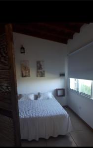 - une chambre avec un lit blanc et une fenêtre dans l'établissement Cabaña Marilau monoamb, à Camet Norte