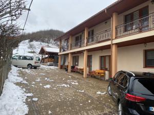 um carro estacionado ao lado de um edifício na neve em Садиба У Дохтора Відпочинок у Карпатах em Golubinoye