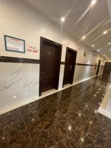 um quarto com duas portas e um piso de mármore em دار المسك em Dammam