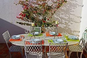 einen Tisch mit Stühlen und einen Tisch mit einer Pflanze in der Unterkunft Stunning 3 bed Villa in Vale do Lobo with Resort Membership 3 mins From Beach and Golf in Loulé